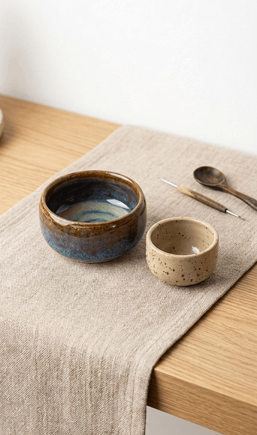 Two ceramic pots on a table cloth